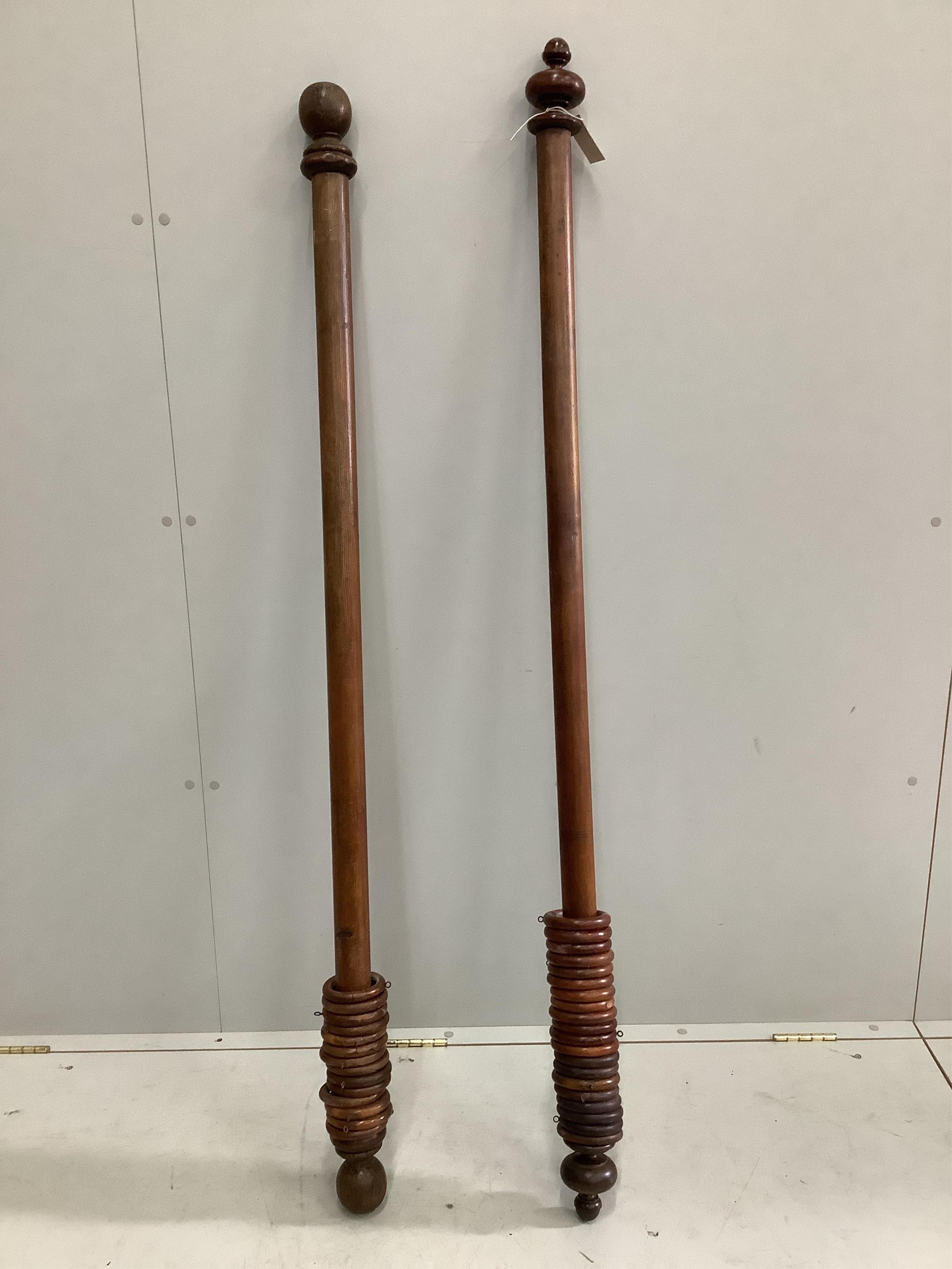 Two Victorian mahogany and pine curtain poles with rings, larger width 161cm. Condition - fair